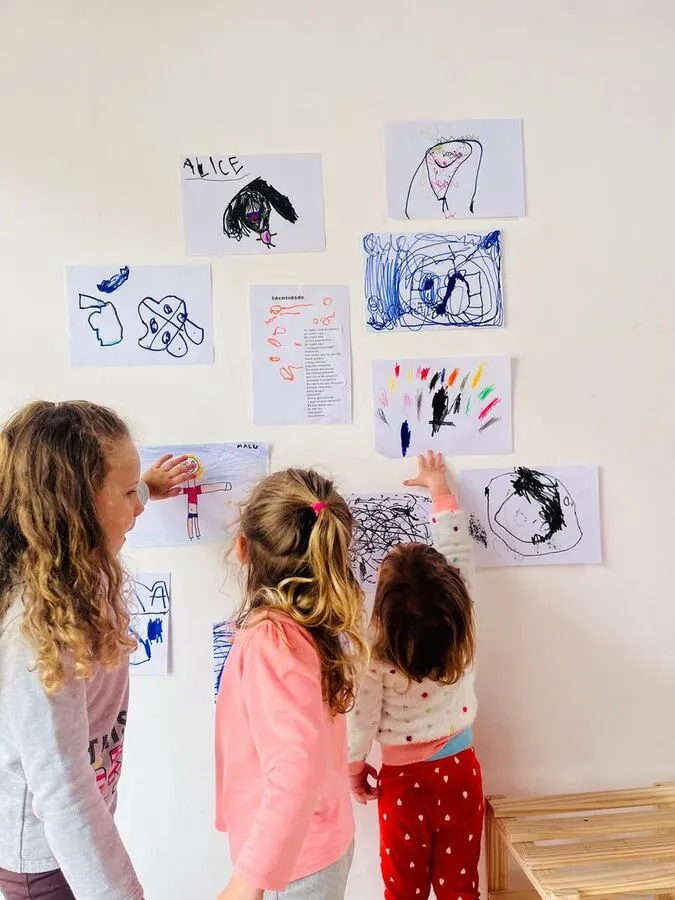 Crianças observando desenhos na parede do Grupo Fixo do Espaço Santa Gianna em Curitiba